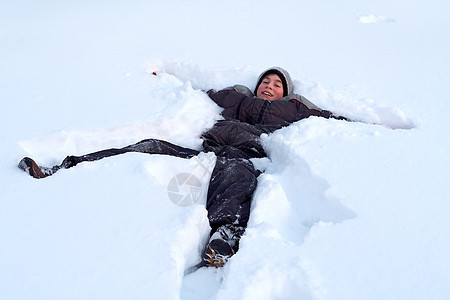 欢乐男孩在清雪中躺着投标蓝色幸福说谎男孩们帽子男性孩子们青年男生图片