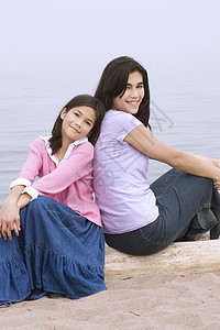 两个姐妹坐在沙滩旁图片