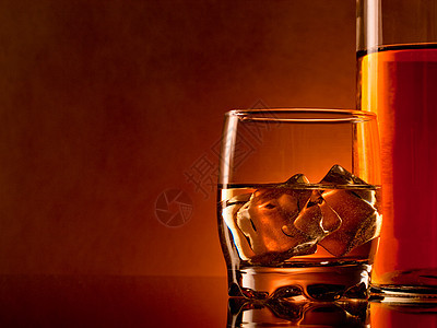 威士忌反射色彩玻璃棕色瓶子冰块酒精饮料麦芽琥珀色背景图片