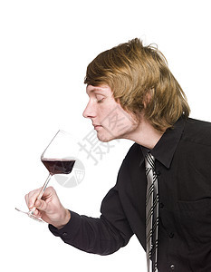 男人闻着葡萄酒的香味测试酒精领带享受工作室食物香气奢华红色图片