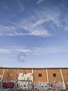 挂着涂鸦的砖墙砖房大厅房子艺术天空平铺工业土坯建筑学处所图片