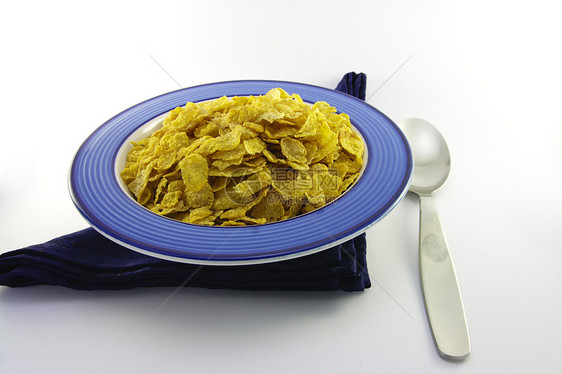 在蓝碗中玉米片和勺子小吃蜂蜜午餐餐巾营养小麦谷物饮食玉米食物图片