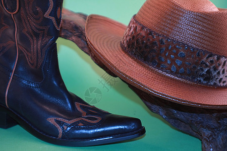 牛仔帽和靴子绿背景图片