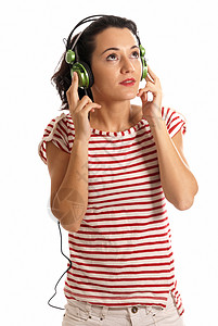 年轻女性用耳机在白色背景旁听音乐的年轻女性喇叭微笑幸福黑发乐趣快乐享受头发青年喜悦图片