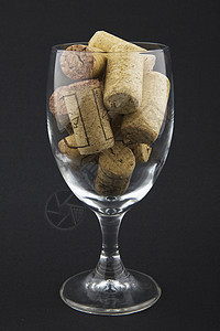 装满软木箱的葡萄酒杯酒精黑色酒杯玻璃软木背景图片