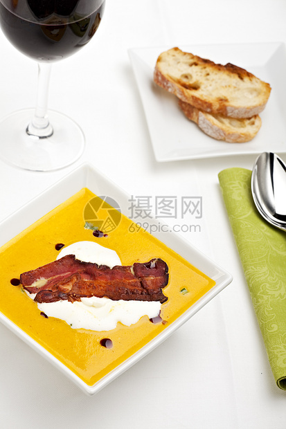 传统南瓜汤和一连串培根盘子熏肉条纹酒杯面包奶油状奶油勺子南瓜课程图片