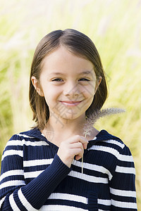微笑的年轻女孩快乐草地童年闲暇毛衣孩子青年公园女性幸福图片