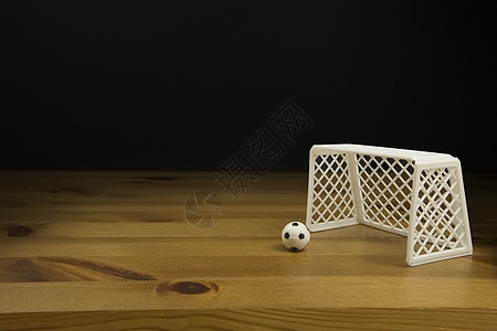 在木桌上贴近一张表 顶尖的足球和球门柱摄影桌子影棚深色水平背景背景图片