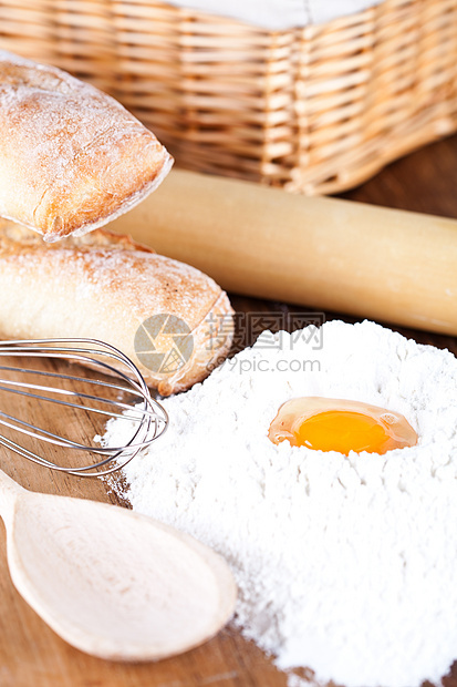 面包 面粉 鸡蛋和厨房用脆皮小麦耳朵篮子勺子棕色木头用具黄色蛋黄图片