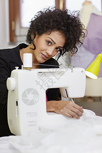 配缝纫机的时装设计师机器工作室专注缝纫职业裙子制造业人体拉丁操作图片