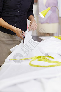 在时装设计室工作的妇女成人职业企业家磁带裁缝剪刀工人衣服职场裁剪图片