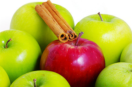 绿色苹果背景 一个红苹果和肉桂木棒图片