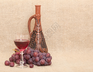 Clay 瓶 葡萄和玻璃 放在画布背景上图片