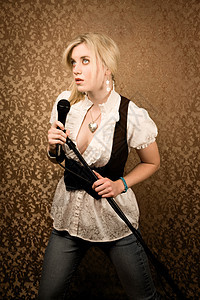 漂亮的年轻歌手或带麦克风的喜剧演员卡拉ok演员艺人音乐衬衫项链女士女歌手金发女郎主持人图片