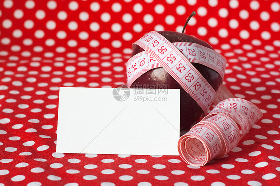 红苹果和红色背景和卡片上的测量磁带图片