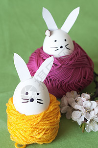 装饰复活节兔子和樱花花黄色树枝绿色紫色粉色花朵绞线耳朵花束图片