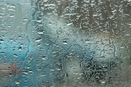 窗口上的雨滴宏观风暴水滴灰色蓝色液体运动天气窗户背景图片