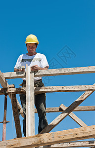 忙于形式工作准备工作的脚手架上的建筑工人图片