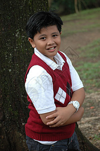 小男孩站在树旁站立黑色白色手表红色男性孩子数字孩子们公园衬衫图片