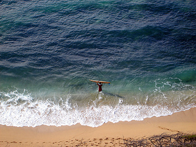 Surfer的空中视图 将冲浪板带入水中 Damond Hea图片