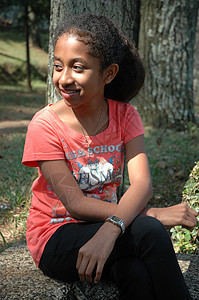 小女孩坐在树旁的树边身体青年眼睛数字棕色衬衫绿色白色未成年人公园图片