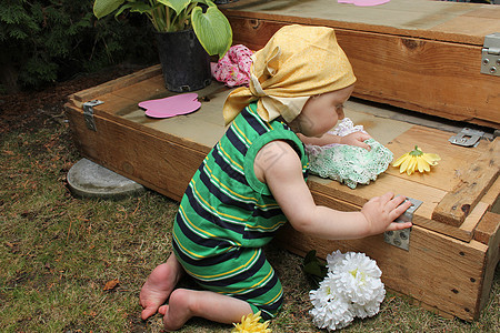 在乐园中的婴儿男性孩子树干木箱头巾晴天生活花园花朵衣服图片