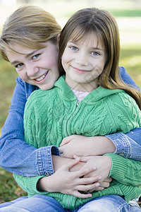两姐妹会乐趣家庭孩子们拥抱微笑青少年公园兄弟姐妹女孩女性图片
