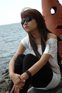 戴墨镜的年轻女士太阳镜假期海滩青少年衬衫黑色身体女孩牛仔裤头发图片