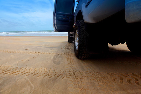 海岸车乐趣车轮反射土地踪迹橙子蓝色天空海洋沙丘图片