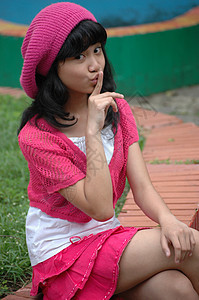 可爱的女孩坐在公园里孩子们女士数字青年帽子女性身体粉色黑色衬衫图片