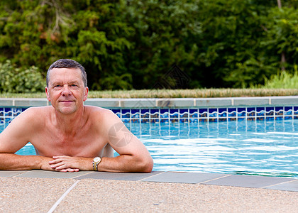 按游泳池边缘排列的老年男子棕褐色蓝色闲暇男性游泳者退休幸福后院肩膀男人图片