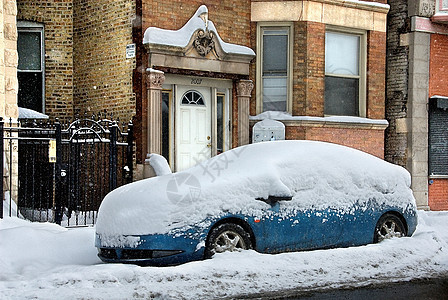 城市街上停着的车被雪覆盖了图片