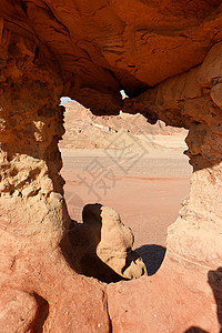 沙漠中橙色沙石岩的窗口橙子风化窗户山脉沙漠游客风景红色砂岩远足图片