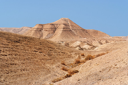 落岩沙漠景观丘陵干旱石头岩石天空黄色环境橙子山脉蓝色图片