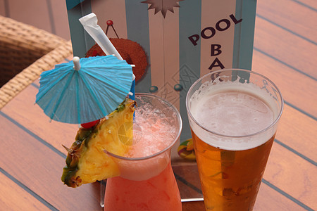 一杯水果鸡尾酒和一杯啤酒稻草饮料蓝色玻璃派对茶点橙子酒吧热带果汁图片