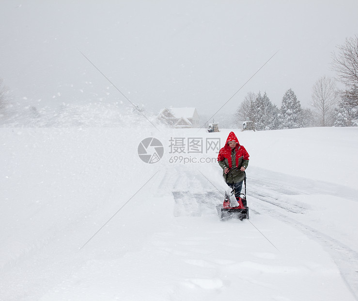 男子在雪车上使用吹雪机红色季节性力量季节天气白色鼓风机暴风雪风暴夹克图片