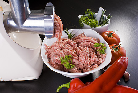 含有薄粉和蔬菜的肉研磨机餐具盘子厨房肉类屠宰场迷迭香红色草药胡椒食物图片