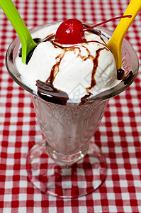 香草冰淇淋和配樱桃和巧克力调味粉的勺子图片