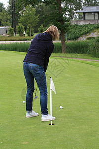 女性在绿薯片上练习高尔夫高尔夫球闲暇白色运动俱乐部绿色图片