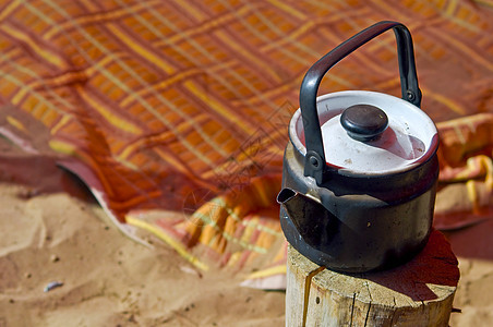 苏酸茶壶树桩木头饮料日光喷口摄影黑色毯子海滩金属图片