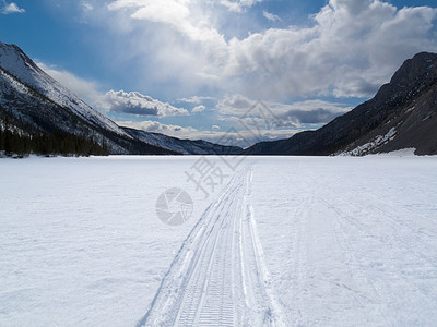 在冰冻的山湖上 利用了冬季足迹森林地区晴天小路云杉荒野气候天空树木农村图片