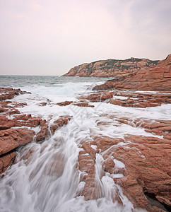 岩石海岸和模糊水域石头天空野生动物地平线冲浪阳光蓝色边缘波纹日出图片