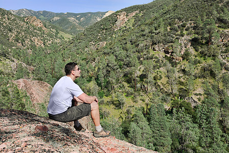 人类在岩石上男性思维游客蓝色休息远足者假期闲暇悬崖男人图片