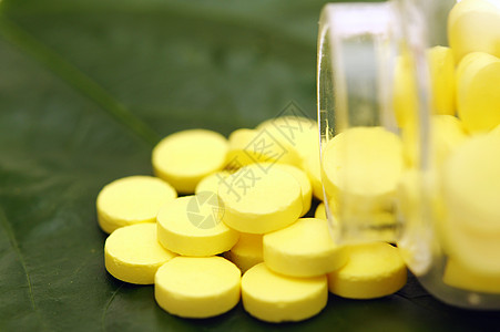 绿叶上的黄黄药片绿色药店草本制药治疗白色黄色卫生生物药品图片