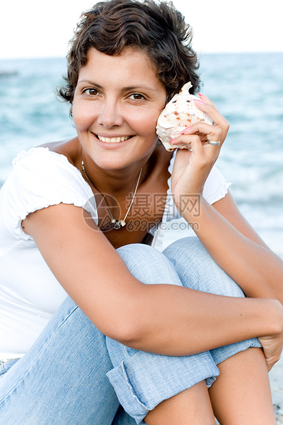 妇女在海上的海岸里黑发美丽牛仔裤场景棉布热带皮肤海滩旅行头发图片