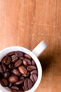 盛满咖啡豆的茶杯美食宏观酒吧咖啡种子唤醒粮食桌子闲暇咖啡店图片