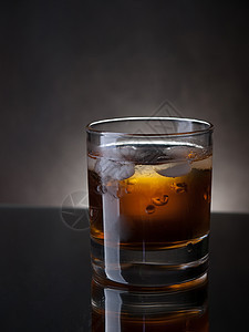 威士忌和冰酒精琥珀色反射玻璃图片