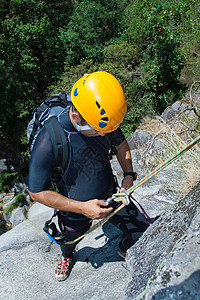 男人用绳索来排泄行动男士边缘勇气瀑布地形峡谷头盔登山冒险图片