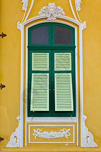 黄色墙上的绿窗被特写控制板木头财产窗格窗户建筑框架水泥房子树木图片