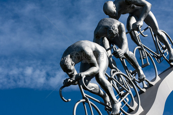 三个在斜坡上的骑自行车的人运动跑步者速度雕塑团队轮子蓝色传奇历史天空图片